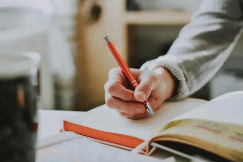 Person mit Stift und Papier