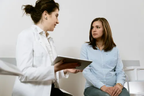 Arzt im Gespräch mit einer besorgten Patientin