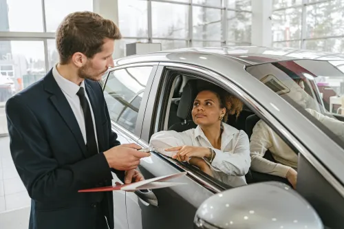 Autohändler übergibt Schlüssel an glücklichen Kunden