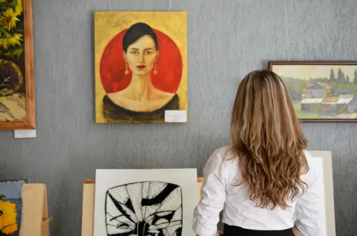 Frau betrachtet ein Gemälde in einer Kunstgalerie